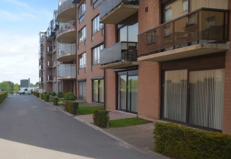 Avant : appartement en rez-de-chaussée sans film — depuis la rue, on voit à l'intérieur par les baies vitrées