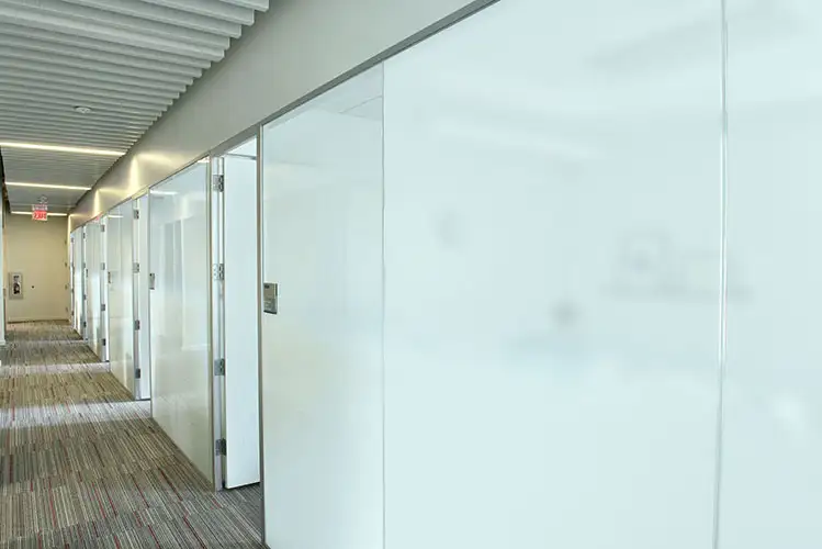 Couloir de bureaux avec cloisons vitrées dépolies sur toute la hauteur, confidentialité continue