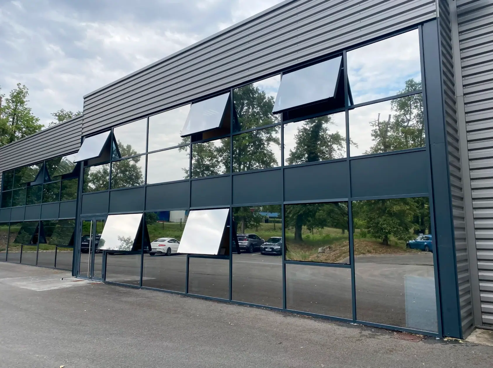 Façade vitrée d'immeuble tertiaire traitée en film miroir sans tain par PrivTeint, effet miroir uniforme