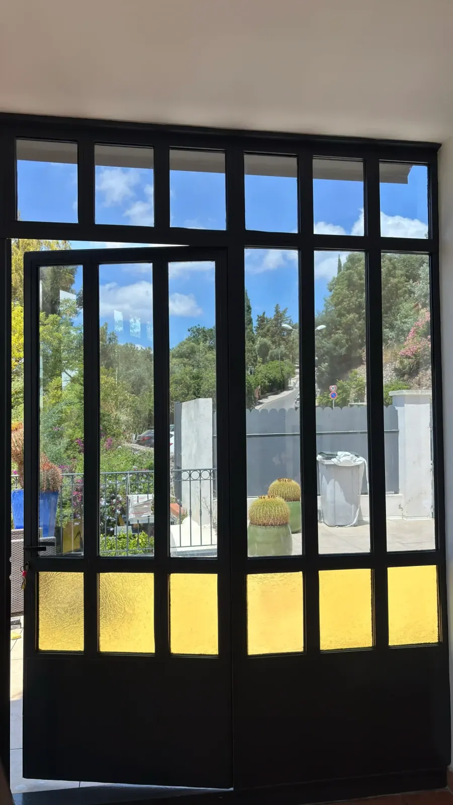 Vue depuis l'intérieur de la véranda à Hyères : malgré le film miroir, la vitre reste transparente et la vue sur le jardin est dégagée