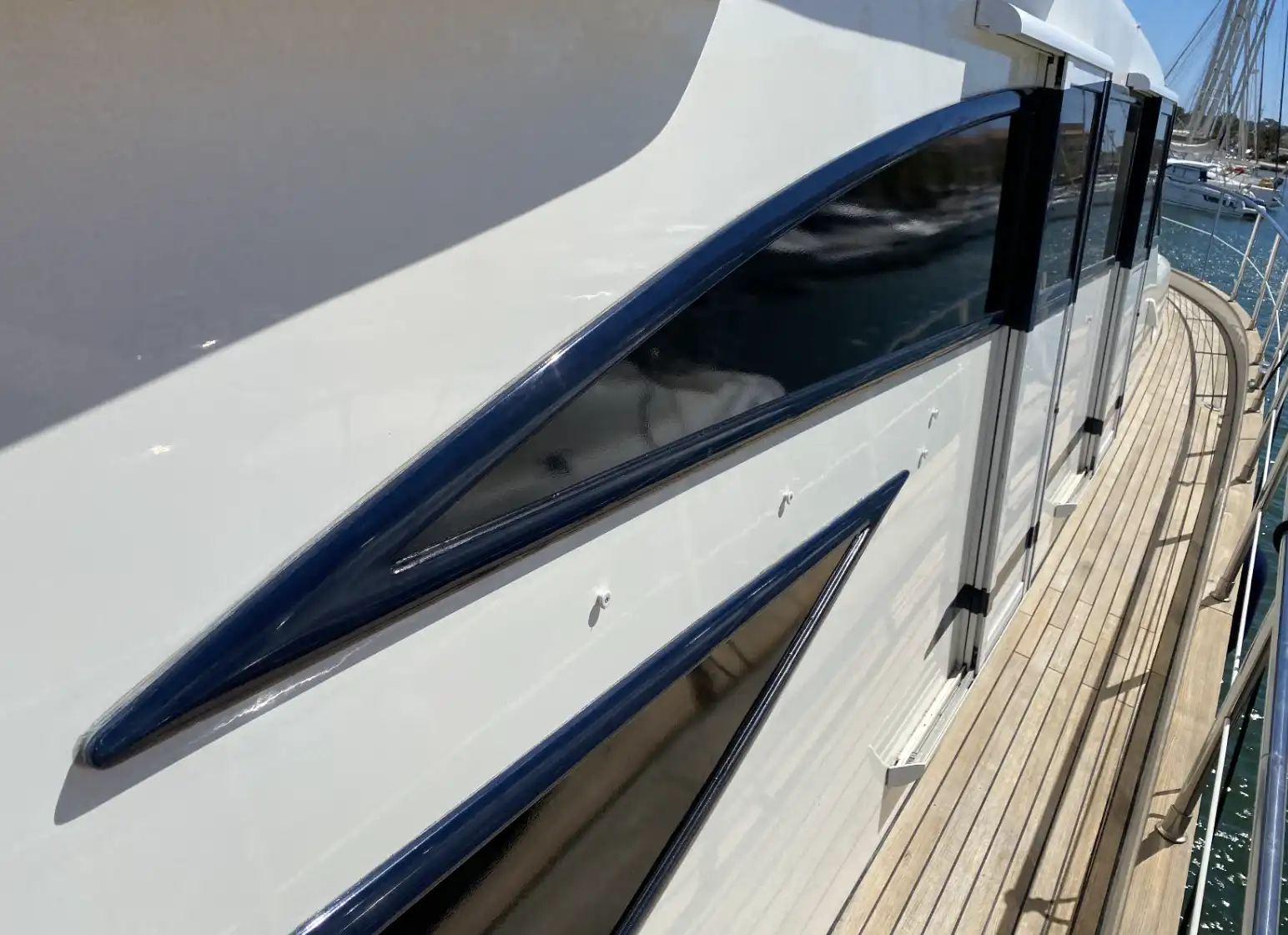 Yacht à coque bleue aux vitrages teintés par PrivTeint dans un port du Var, films marins