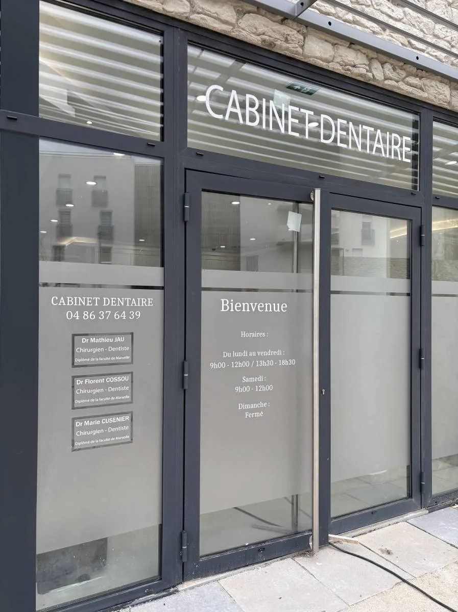 Façade de cabinet dentaire avec vitrophanie dépolie et informations pratiques posées sur les vitrages