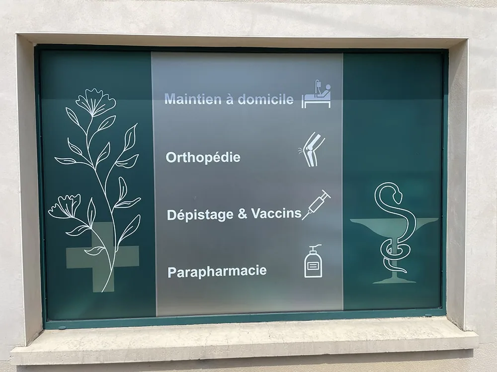 Vitrine de pharmacie en film dépoli avec signalétique des services : maintien à domicile, orthopédie, dépistage, parapharmacie